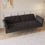Canapé en velours noir orné de clous décoratifs et accompagné d'un coussin assorti.