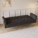 Canapé en velours noir orné de clous décoratifs et accompagné d'un coussin assorti.